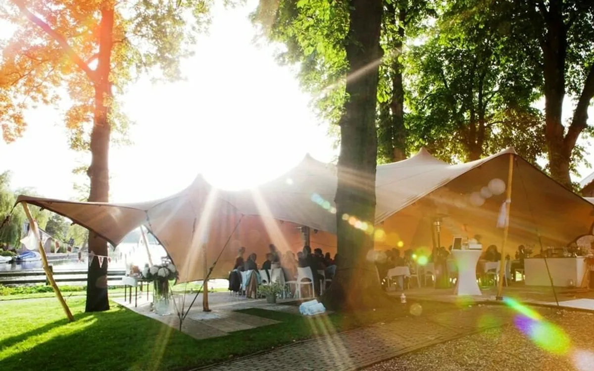 Stretchtenten tussen de bomen op een zonnige evenementlocatie